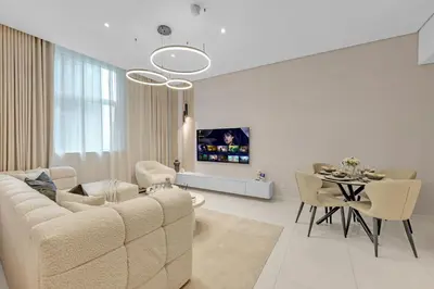 a white living room with a couch and a table at Lavish & Cozy 1BR Apt in the heart of Business Bay in Dubai