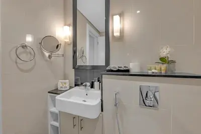 a white bathroom with a sink and a mirror at Lavish & Cozy 1BR Apt in the heart of Business Bay in Dubai