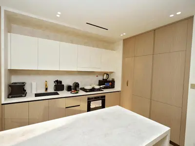 a kitchen with white cabinets and a counter top at Bright Apartment in JVC with Pool in Dubai