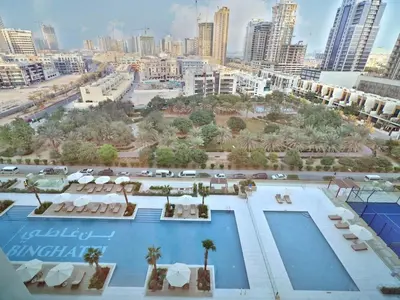 arial view of a pool with a city in the background at Bright Apartment in JVC with Pool in Dubai