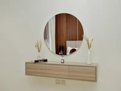 a dressing table with a mirror on a wall at Bright Apartment in JVC with Pool in Dubai