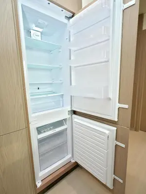 an empty refrigerator with its door open in a kitchen at Bright Apartment in JVC with Pool in Dubai