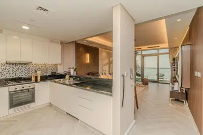a kitchen with white cabinets and a view of the ocean at Paramount Midtown Luxury 2BR Sleeps 7 Near Business Bay Metro and Dubai Mall in Dubai