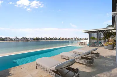 a swimming pool with two lounge chairs next to the water at Premium 4 BR Villa in Palm Jumeirah with Private Pool in Dubai