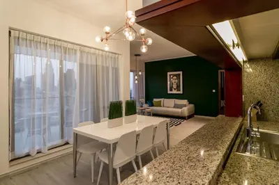 a kitchen and living room with a white table and chairs at La Dolce Vita in Dubai