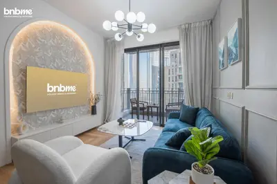 a living room with a blue couch and a table at bnbmehomes - Stand Point Tower A in Dubai