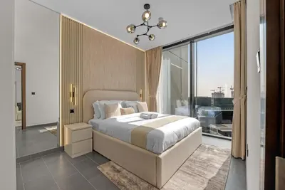 a bedroom with a large bed and a large window at Waves - Modern & Cozy 1BR Apt Close to Down Town Dubai in Dubai