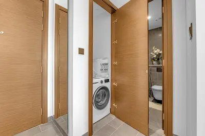 a bathroom with a washing machine and a toilet at Waves - Modern & Cozy 1BR Apt Close to Down Town Dubai in Dubai