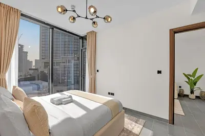 a bedroom with a bed and a large window at Waves - Modern & Cozy 1BR Apt Close to Down Town Dubai in Dubai