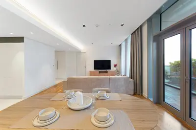 a living room with a table with dishes on it at Bluewaters Residences 1BR Prime Sea and Ain View in Dubai