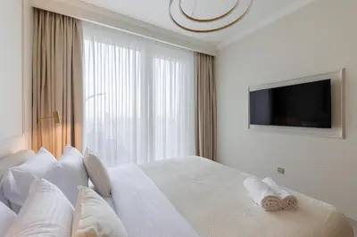 a white bedroom with a large bed with a window at Chic 1BR Sea View, Palace Beach Residence in Dubai