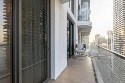 a balcony with a chair and views of the city at Chic 1BR Sea View, Palace Beach Residence in Dubai