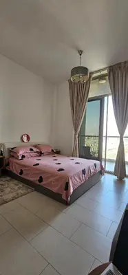 a bedroom with a bed and a large window at Peace Home in Dubai
