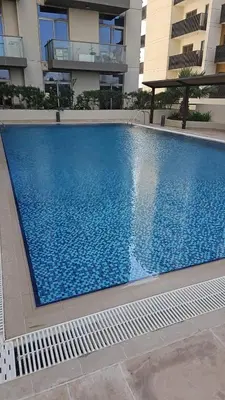 a large blue swimming pool in front of a building at Peace Home in Dubai