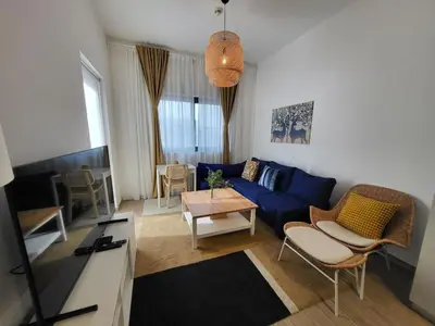 a living room with a blue couch and a table at Bright 2BR Apartment 5-Min Walk to Metro & Mall 1124 in Dubai