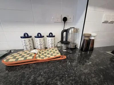 a counter top with a blender and four cups on it at Bright 2BR Apartment 5-Min Walk to Metro & Mall 1124 in Dubai