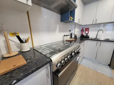 a kitchen with a stove and a counter top at Bright 2BR Apartment 5-Min Walk to Metro & Mall 1124 in Dubai