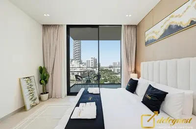 a bedroom with a large white bed and a large window at Bright 1BR Apartment in Binghatti Phoenix High-Floor Views in Dubai
