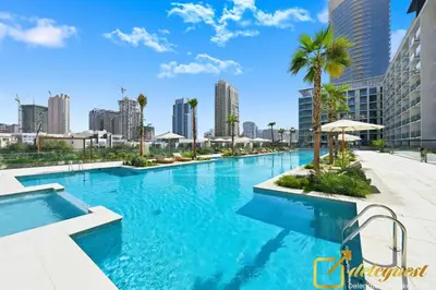a swimming pool with a city skyline in the background at Bright 1BR Apartment in Binghatti Phoenix High-Floor Views in Dubai