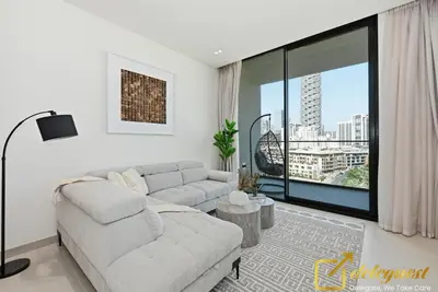 a living room with a couch and a large window at Bright 1BR Apartment in Binghatti Phoenix High-Floor Views in Dubai
