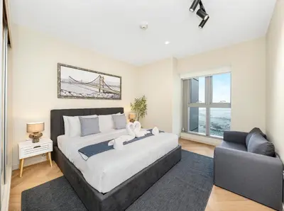 a bedroom with a large bed and a couch at Oceanview Palmview Dubai Eye Ain Marina 2BHK in Dubai