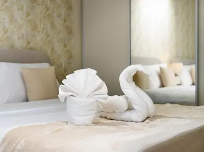 a towel animal sitting on a bed in a hotel room at Oceanview Palmview Dubai Eye Ain Marina 2BHK in Dubai