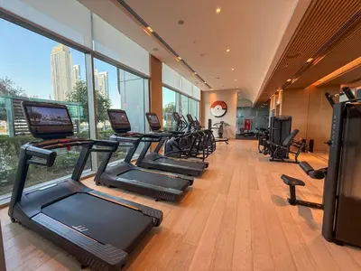a gym with a row of treadmills and elliptical machines at 18 Vida Dubai Mall Newly Furnished 1 bedroom in Dubai