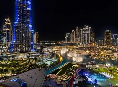 a night view of a city with a river and buildings at Ultra-luxury 2BHK apartment Stunning Burj Khalifa & Fountain view in Dubai