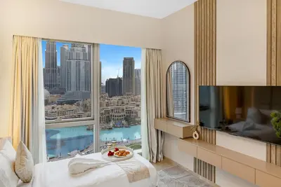 a bedroom with a large window with a view of the city at Ultra-luxury 2BHK apartment Stunning Burj Khalifa & Fountain view in Dubai