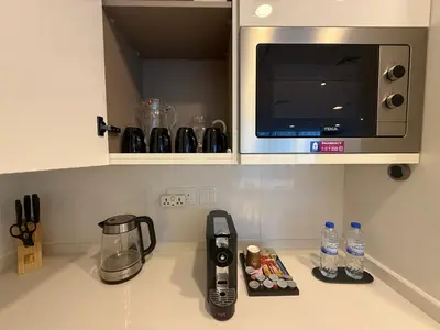 a kitchen counter top with a microwave and a counter sidx sidx sidx at Marina View 2BHK, Spacious Apartment in a Prime Location, Quick Access to Tram, Metro & Beach in Dubai