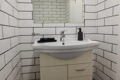 a white bathroom with a sink and a mirror at Marina View 2BHK, Spacious Apartment in a Prime Location, Quick Access to Tram, Metro & Beach in Dubai