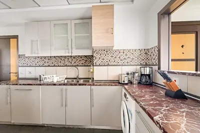 a kitchen with white cabinets and marble counter tops at VayK - Spacious 3BR in JBR with Beach Access in Dubai
