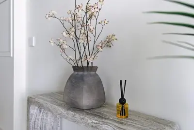 a vase with flowers sitting on a table at Luxury Branded Suite with Direct Private Beach Access & Sea Views in Dubai