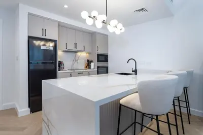 a kitchen with a white counter and a black refrigerator at Upgraded Serene 1BR Retreat in The Greens in Dubai