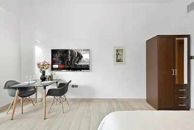 a bedroom with a table and chairs and a tv at Dubai JVC - Oxford Residence 2 - Parking&Balcony in Dubai