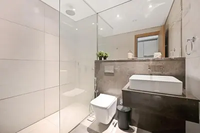 a bathroom with a toilet and a sink and a mirror at Dubai JVC - Oxford Residence 2 - Parking&Balcony in Dubai