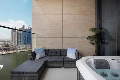 a balcony with a couch next to a bath tub at Luxury Studio with Private Jacuzzi in Business Bay in Dubai