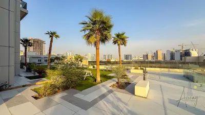 a view of a city with palm trees and buildings at Skyline View Stu 20th Floor Regina Tower, JVC in Dubai