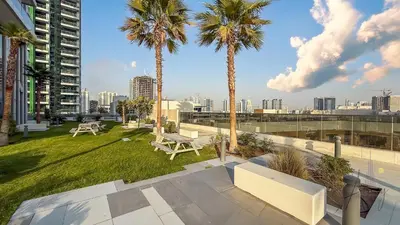 a patio with palm trees and a view of the city at Skyline View Stu 20th Floor Regina Tower, JVC in Dubai