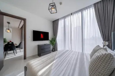 a bedroom with a white bed and a large window at Creek Vista Elegance-1BRBurj Khalifa View in Dubai