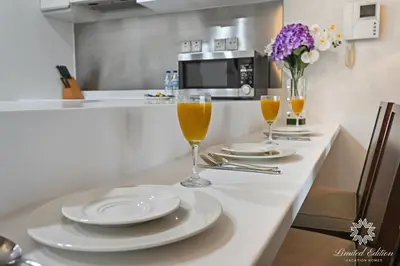 a kitchen counter with two glasses of orange juice at Emaar Residences Fashion Avenue - 1BR - Connected to Dubai Mall - Pool with Burj View in Dubai
