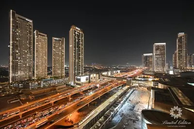 a city at night with traffic on a freeway at Emaar Residences Fashion Avenue - 1BR - Connected to Dubai Mall - Pool with Burj View in Dubai