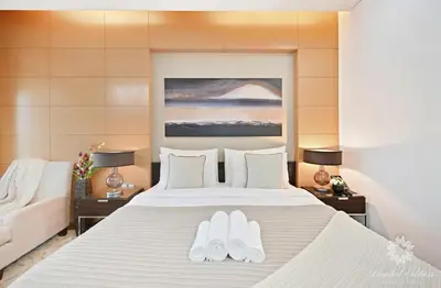 a bedroom with a large bed with two white shoes on it at Emaar Residences Fashion Avenue - 1BR - Connected to Dubai Mall - Pool with Burj View in Dubai