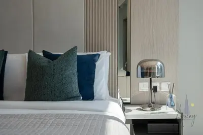 a bedroom with a bed with blue pillows and a side table at Luxe Desiged Stu Dubai Marina Dream LIV Marina in Dubai