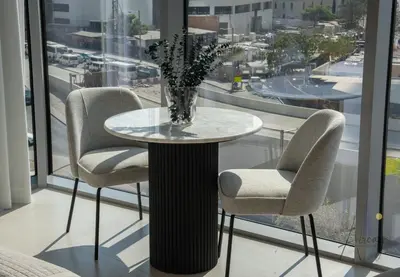 a table with two chairs and a vase with flowers on it at Luxe Desiged Stu Dubai Marina Dream LIV Marina in Dubai