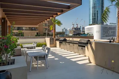 a rooftop patio with tables and chairs on a building at Luxe Desiged Stu Dubai Marina Dream LIV Marina in Dubai