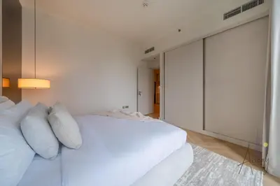 a white bedroom with a large white bed with pillows at Elite Beachfront Living Stylish High-Floor 1BR in Dubai