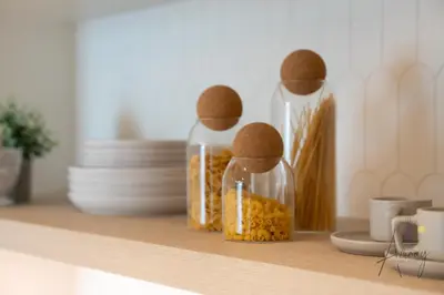 three glass jars filled with food sitting on a shelf at Elite Beachfront Living Stylish High-Floor 1BR in Dubai