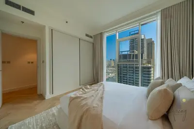 a bedroom with a large bed and a large window at Elite Beachfront Living Stylish High-Floor 1BR in Dubai