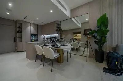 a dining room with a table and chairs and a kitchen at Cosy Corner 1BR Designer Apt Luxe Nest in JVC in Dubai